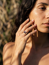 Crimson Sentinel Garnet Ring shown worn on hand with hammered sterling silver band and deep red gemstone.