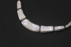 Close view of Mother of Pearl sterling silver necklace showing soft nacre shimmer and linked shell panels.