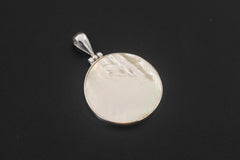 Mother of Pearl round pendant displayed on dark background with polished sterling silver bezel.
