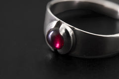 Close view of Garnet sterling silver ring showing domed red cabochon and smooth polished band.