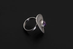 Side view of adjustable Amethyst sterling silver ring showing raised disc face and polished band.