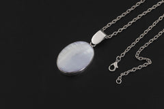 Mother of Pearl sterling silver pendant displayed on dark background with oval shell cabochon and chain.