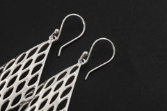 Diamond lattice sterling silver earrings displayed on dark background with hook ear wires.
