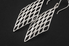 Close view of sterling silver geometric earrings showing polished open lattice pattern and hook fittings.
