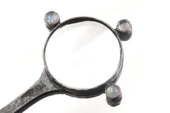 Close view of Moonstone magnifier pendant showing central lens and raised Blue Moonstone settings.