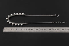 Pearl beaded sterling silver necklace shown beside a ruler for length and size reference.