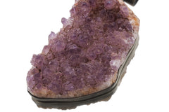 Large raw Amethyst druzy pendant held in hand showing natural purple crystal points and silver backing.