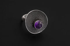 Amethyst Solar Disc Ring displayed on dark background with round purple stone and dense silver texture.