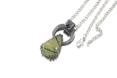 Blue Moonstone Peridot heirloom pendant shown on white background with oxidized sterling silver brutalist claw setting.