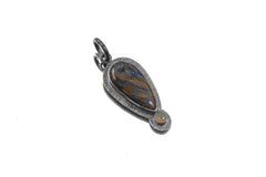 Pietersite Ethiopian Opal sunburst pendant shown on white background with textured sterling silver setting.