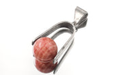 Rhodochrosite spinning pendant shown on white background with high-shine sterling silver U-shaped holder.
