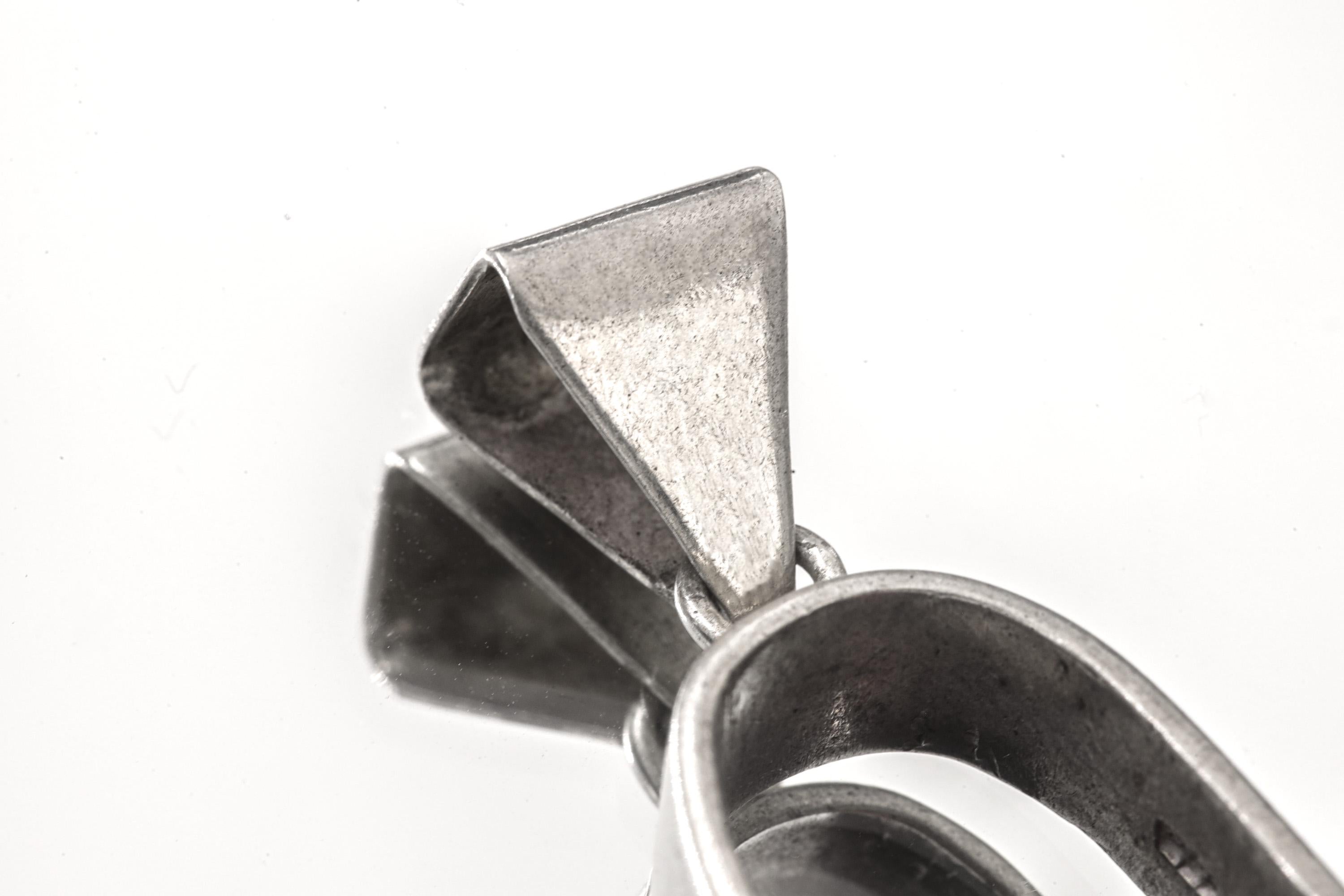 Close-up of triangular sterling silver bail and U-shaped holder on Rhodochrosite rotating pendant.