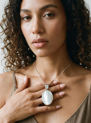 Mother of Pearl oval pendant shown worn on model as a luminous sterling silver shell necklace.