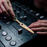 Gold-plated Amethyst cutter spoon pendant shown on DJ mixer as a functional ritual talisman.