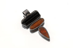 Guardian Flame triple stone pendant shown on white background with raw Black Tourmaline and two Red Kyanite stones.