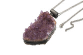 Raw Amethyst cluster pendant shown with silver chain on white background and oxidized sterling silver setting.