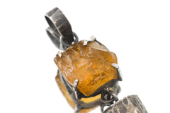 Close-up of raw sparkling Sunstone in an oxidized sterling silver claw setting with handmade texture.