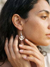 Close view of freshwater Pearl earrings with organic flower-shaped sterling silver settings.