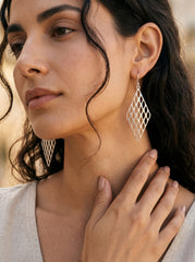 Sterling silver diamond lattice earrings shown worn on model as long geometric statement drops.