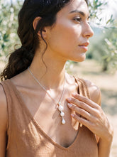 Triple Pearl sterling silver pendant shown worn on model with luminous vertical cascade design.