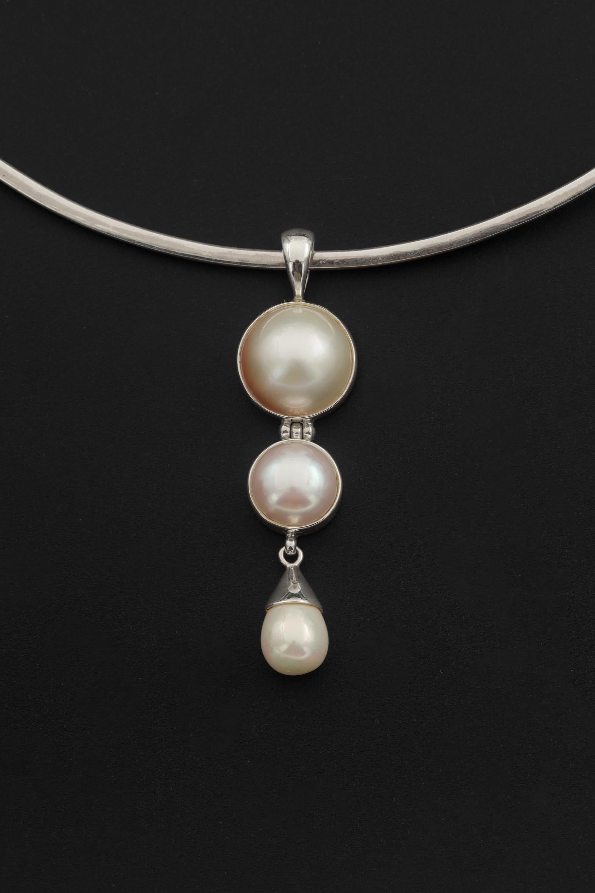 Pearl pendant shown worn on model as an elegant handmade sterling silver necklace.
