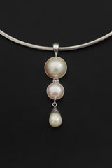 Pearl pendant shown worn on model as an elegant handmade sterling silver necklace.