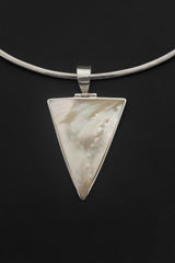 Close detail of triangular Mother of Pearl pendant showing creamy shell pattern and polished silver frame.
