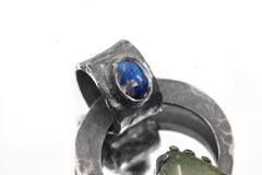 Close-up of Blue Moonstone Peridot pendant showing oxidized silver bail and blue gemstone glow.