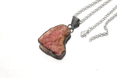 Rose Heart Rhodochrosite pendant shown with silver chain on white background as a handmade crystal necklace.