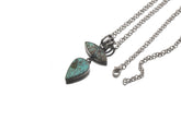 Double Turquoise oxidized sterling silver pendant shown with chain on white background as a bold matrix stone talisman.
