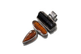 Black Tourmaline and Red Kyanite sterling silver pendant shown on white background with oxidized brushed silver setting.