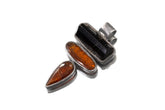 Black Tourmaline and Red Kyanite sterling silver pendant shown on white background with oxidized brushed silver setting.