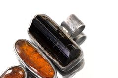 Close-up of Black Tourmaline Red Kyanite pendant showing oxidized silver bezels and faceted red stones.