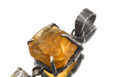 Close-up of raw sparkling Sunstone in an oxidized sterling silver claw setting with handmade texture.