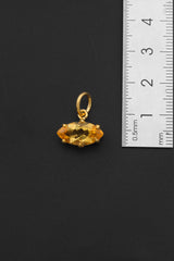 Citrine gold-plated sterling silver pendant shown beside ruler for compact size reference.