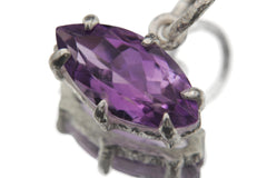 Close view of faceted Amethyst pendant in sterling silver claw setting with rich purple colour.