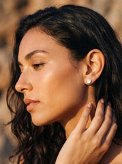 Mother of Pearl sterling silver studs shown worn on model as luminous everyday shell earrings.