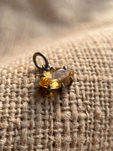 Oxidized sterling silver Citrine marquise pendant shown on burlap with warm golden gemstone.