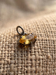 Oxidized sterling silver Citrine marquise pendant shown on burlap with warm golden gemstone.
