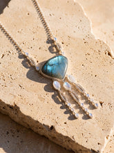 Ocean’s Whisper Radiance necklace shown on sand, with Larimar, Blue Moonstone, Clear Quartz, and sterling silver box chain.