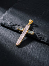Celestial Grace cross pendant shown worn on the chest, with raw Pink Kunzite, Aquamarine, and 18k gold-plated sterling silver.