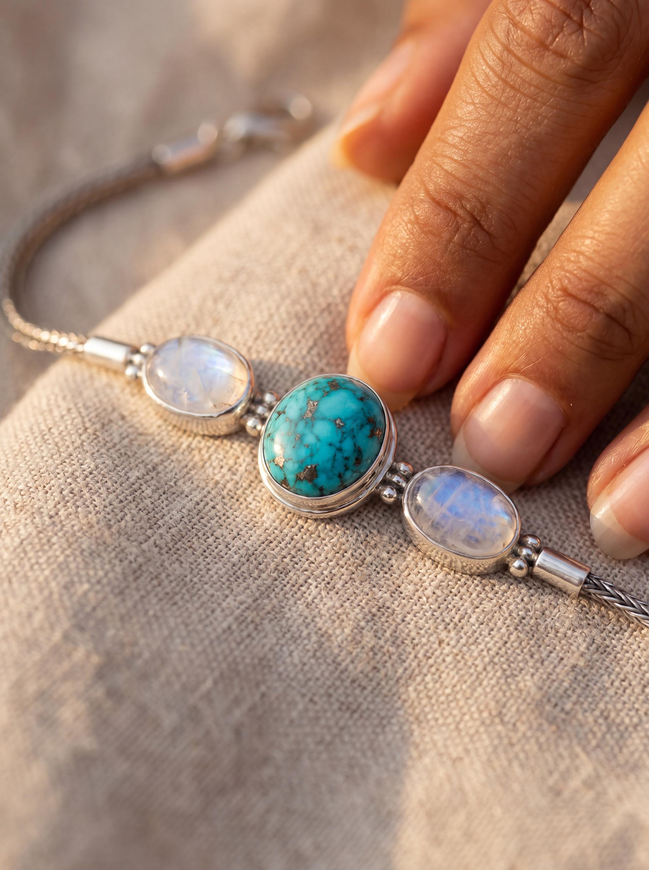 Turquoise and Moonstone sterling silver bracelet shown worn on model with ocean-blue centre stone.