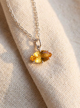 Faceted Citrine marquise pendant shown worn on linen with sterling silver claw setting.