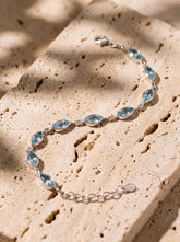 Blue Topaz sterling silver bracelet shown on model with pale blue marquise gemstones and polished silver links.