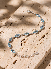 Blue Topaz sterling silver bracelet shown on model with pale blue marquise gemstones and polished silver links.