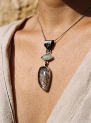 Ethiopian Opal Sapphire and Rutile Quartz pendant shown worn on model as a mystical oxidized silver talisman.