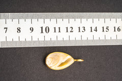 Seashell pendant shown beside a ruler for scale with gold-plated sterling silver bail and hammered bezel.