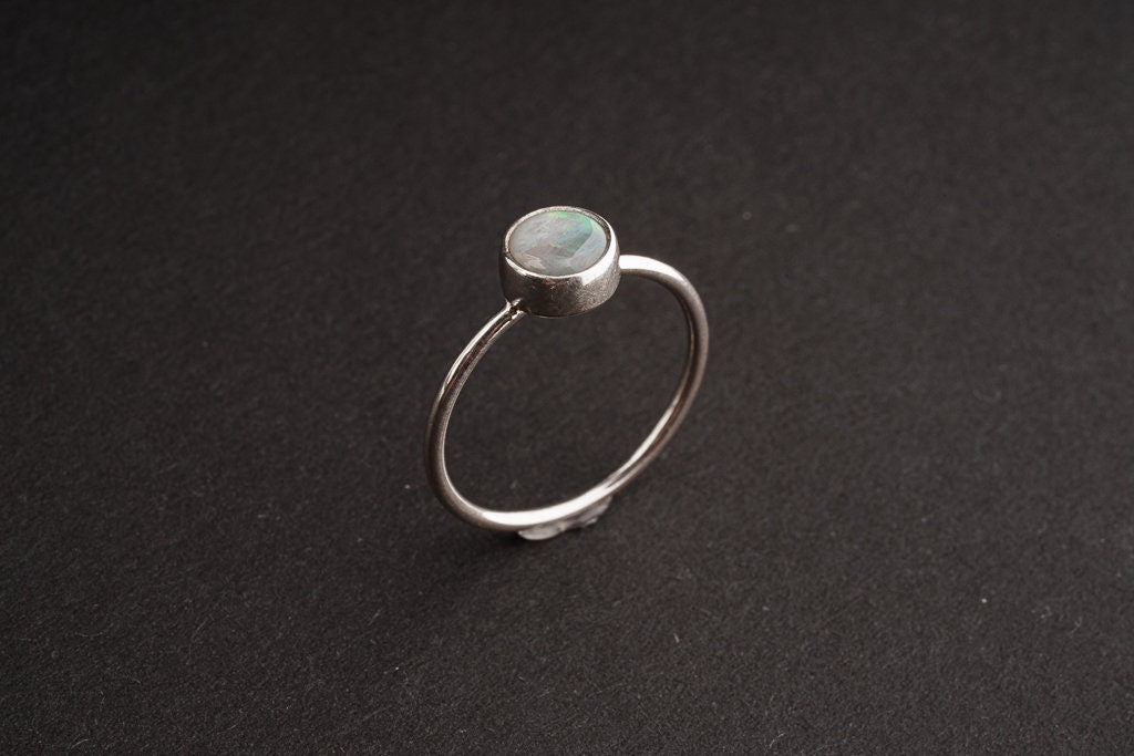 Side view of rough Lightning Ridge Black Opal ring showing the revealing bezel setting and fine sterling silver band.