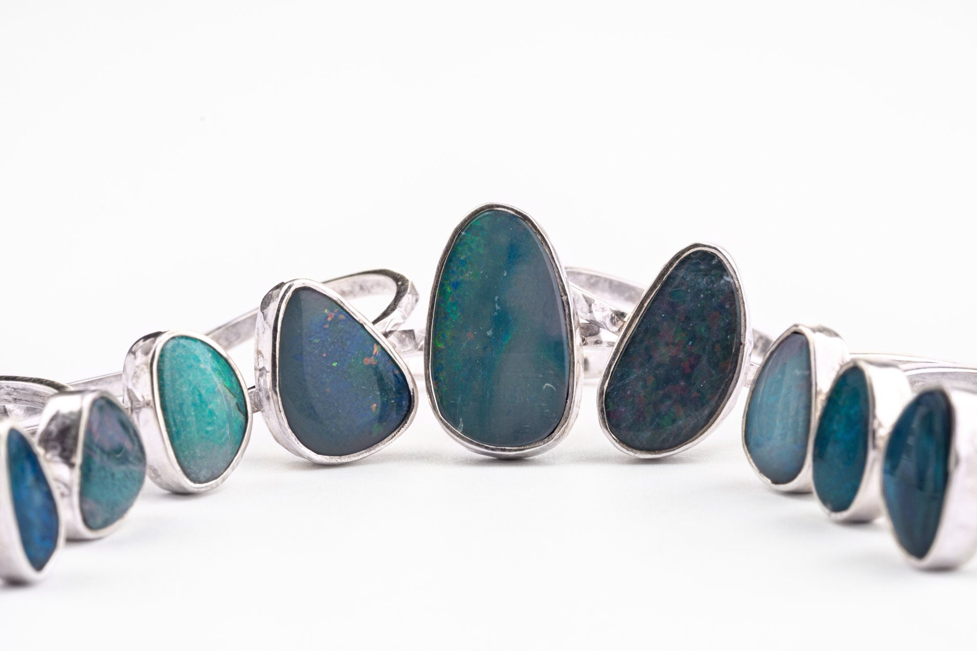 Australian Opal Doublet Rings shown together on white background with different opal shapes and sterling silver settings.