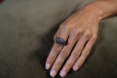 Raw Tanzanite ring shown worn on the hand as a blue-violet December birthstone ring in handmade sterling silver.